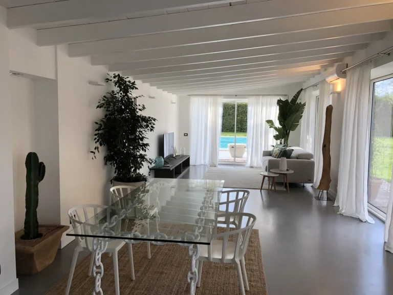 Apartment BELLA: bright open-plan living room with white beams and views of the pool