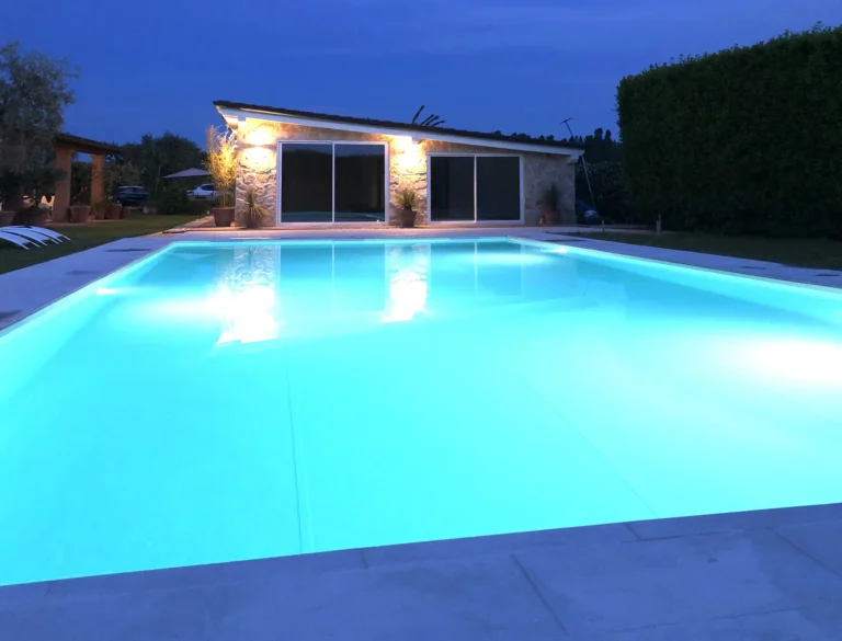 The swimming pool of Dimora Arabella glowing turquoise at dusk